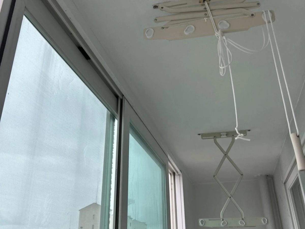 같은 천장 모서리가 곰팡이 제거 후 하얗게 정리되고 새 빨래건조대가 설치된 모습